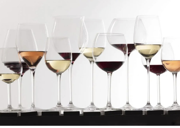 A series of differently shaped wine glasses filled with various colours of wine